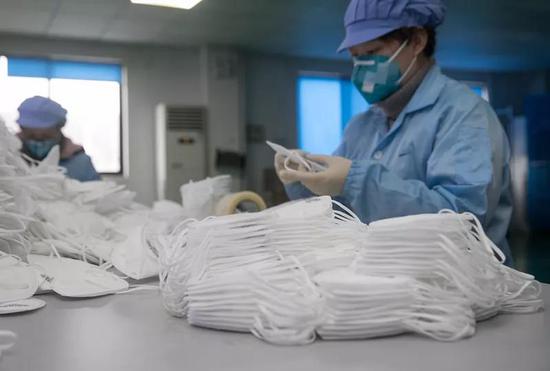 1月26日,上海远钦净化科技有限公司员工在清点制作好的口罩。 新华社 图