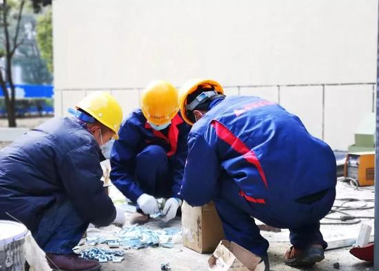工作人员在湖北宜昌第二人民医院加装电梯现场整理物料