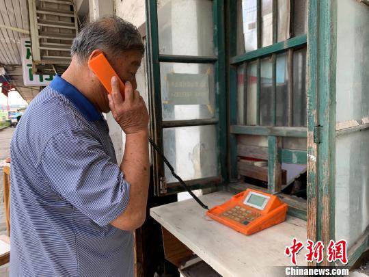 吕树生说,这个电话亭就像家里一样的,每天要到这里来。 康玉湛 摄