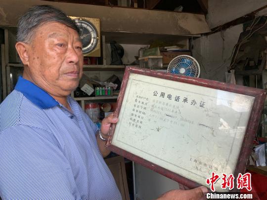 吕树生展示公用电话承办证。 康玉湛 摄