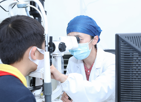 复旦大学附属眼耳鼻喉科医院近视防控便民门诊,医生给小朋友做检查。 徐昊 图