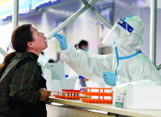 周浦医院工作人员为市民做核酸检测。摄影 王陆杰