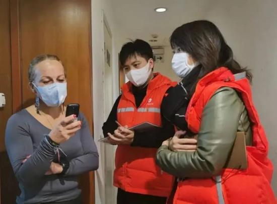 上海市长宁区社区干部与居家隔离的外籍人士进行沟通。上海市长宁区供图