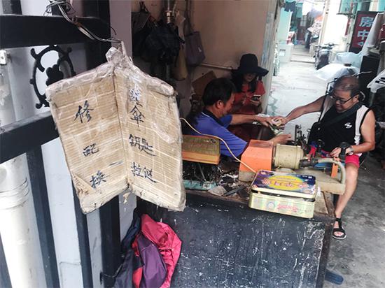 图说:修鞋摊摆在石库门过街楼下的一角。李一能 摄