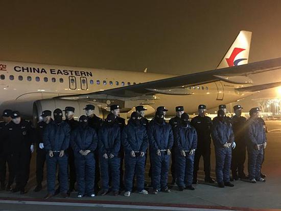 1月30日,犯罪嫌疑人被带下飞机,在停机坪列队。 澎湃新闻记者 朱奕奕 图