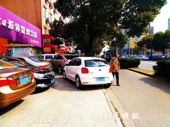 图说:人行道被轿车占据 新民晚报记者 徐驰 摄