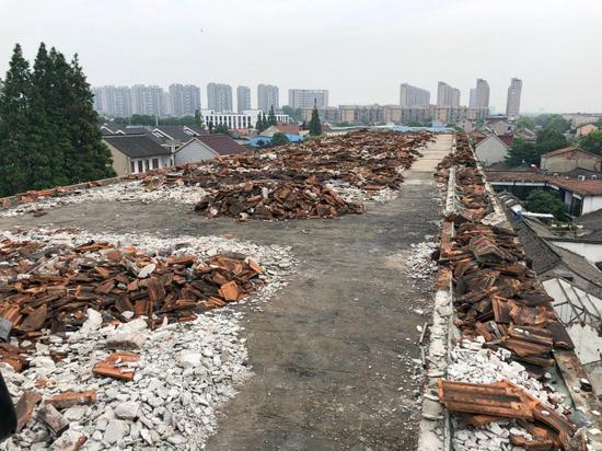 △4层教学楼楼顶,房顶拆卸后产生的红色碎瓦块堆满整个屋面。一旦被风吹落,极易伤人。