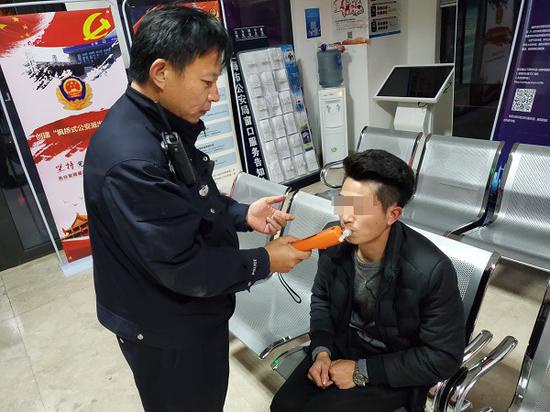 图说:对男子进行呼吸式酒精测试