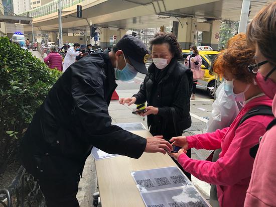 复旦大学附属华东医院门口,入院人员扫码检查近期行程。 澎湃新闻记者 李佳蔚 图