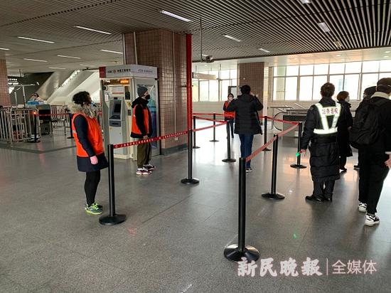 图说:地铁站增加多名工作人员和志愿者,用红线拦出排队通道 曹刚 摄