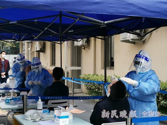 图说:医护人员正用咽拭子进行核酸检测采样 鲁哲/摄