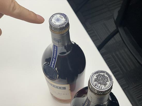 真假马爹利在瓶盖上有明显差异，右为假。澎湃新闻记者 朱奕奕 图