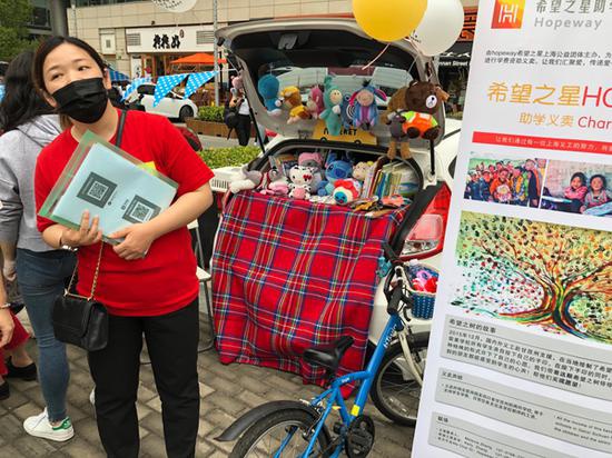 “希望之星助学”公益组织的义工,从自家带来义卖的玩偶等商品。
