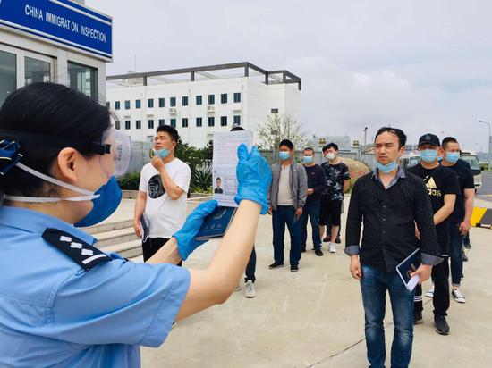来自全国各地的船员汇聚在洋山港登上远洋航行船舶,洋山边检民警室外为船员办理人证对照手续。 本文图片均为 周晓东 摄