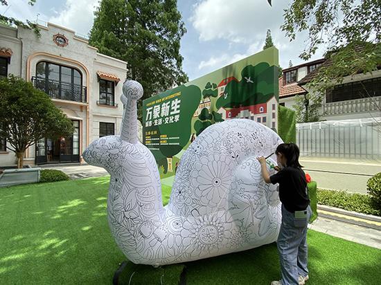 5月23日,一位参加2020“武夷·有意思”万象新生城市·生活·文化季的小朋友在给充气蜗牛填色。