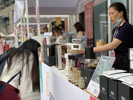 “赭石与樱花粉”咖啡甜品节上有25家咖啡及咖啡周边摊档，一位消费者在挑选咖啡。