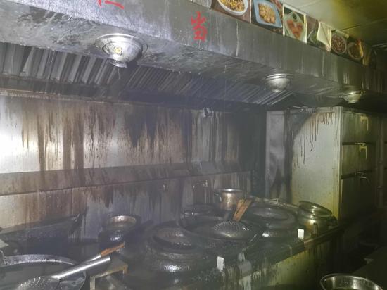 飞洲国际大厦五楼辛香汇餐厅厨房发生火灾,现场被烧焦。徐汇消防供图