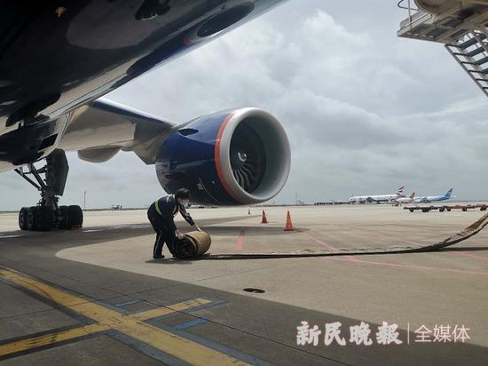 图说：桥载设备操作员正在给飞机接空调