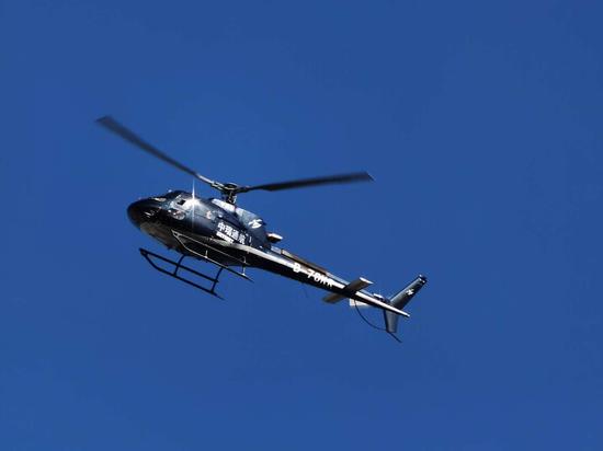 2020年8月5日下午，一架机身上有“中瑞通航”字样的直升飞机飞过居民楼上空。受访者供图