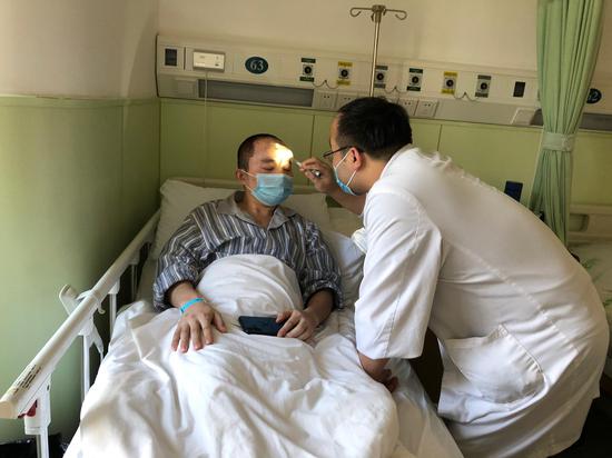 出院前,床位医生李志鹏检查沈杰的伤口情况。 澎湃新闻记者 李佳蔚 图