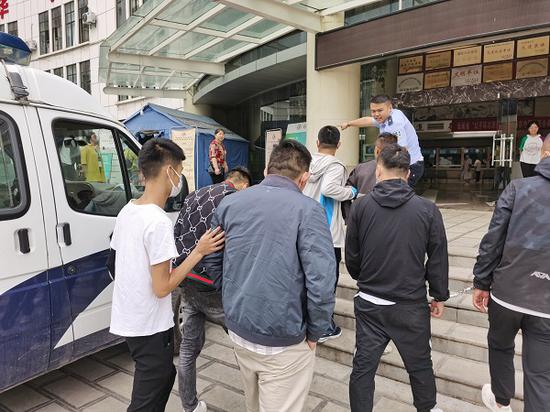 图说:“洗钱”团伙骨干成员被民警押送回沪。普陀公安分局供图