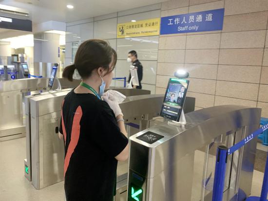 图说:机场工作人员“刷脸”自助通关。陆一行 摄