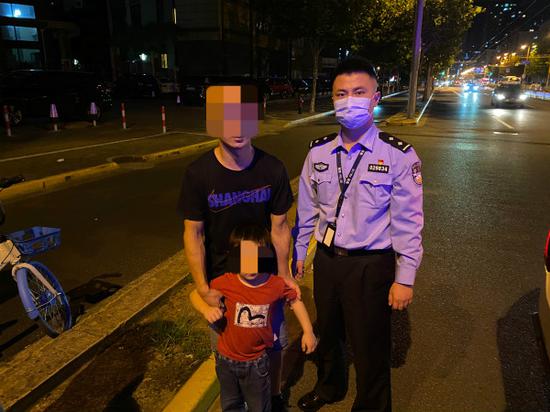 图说:幼童找到父亲后与民警合影