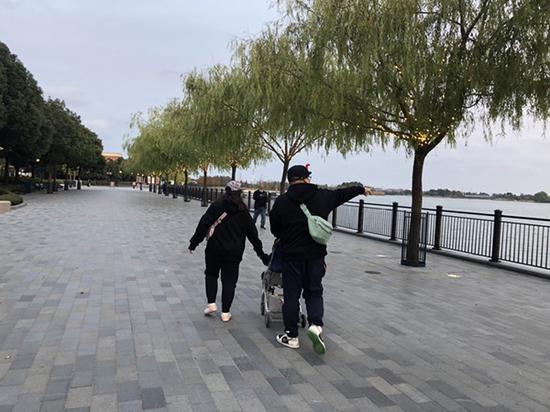 11月23日下午,张女士(左一)一家三口游玩后走出上海迪士尼乐园。 澎湃新闻记者 李佳蔚 图