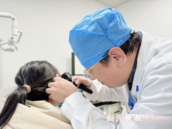 图说:李蕴主任在给患者检查耳朵 左妍 摄