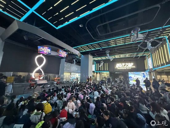  每隔1小时，一场名为“玄涌重生”的多媒体演出就会把“明日行者”整个展区的热度推向“沸点”。图为观众在静候演出开启。 记者摄于现场