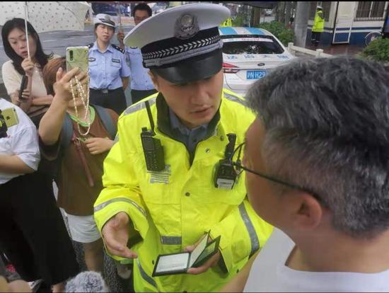 交警王润达向驾驶员介绍驾驶证、行驶证“电子亮证”功能