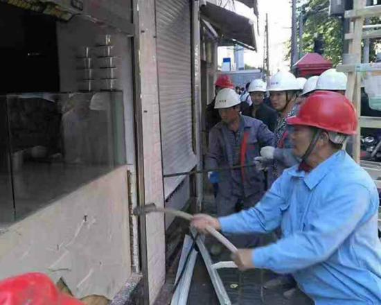 图说:城管正在拆除违法建筑。