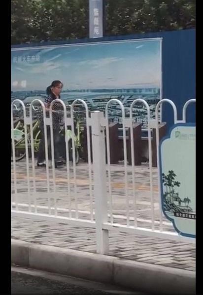 图说:女子持一硬物砸公共自行车固定桩的面板 微博视频供图
