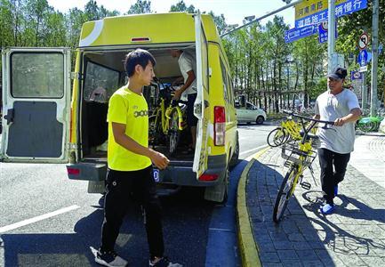 单车企业将联谊大厦门前违停的单车运走 /晨报记者 竺钢