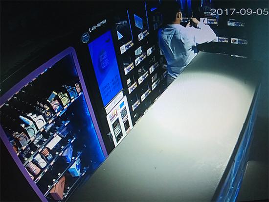 图说:监控录像显示,孔某用螺丝刀撬开一台自动售卖机并实施盗窃。警方提供
