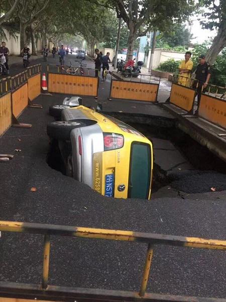 图说:云岭西路一处路面塌陷,途经此处的一辆强生出租车掉入坑中 网友供图