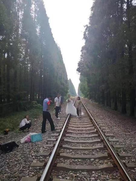 图说:民警制止新人在铁路上摄影。张波 摄