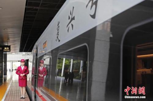 资料图:4月10日,列车员在“复兴号”列车旁迎接旅客的到来。 中新社记者 殷立勤 摄
