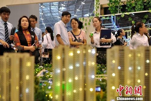 资料图:置业顾问为民众推荐商品房户型。 中新社记者 韦亮 摄