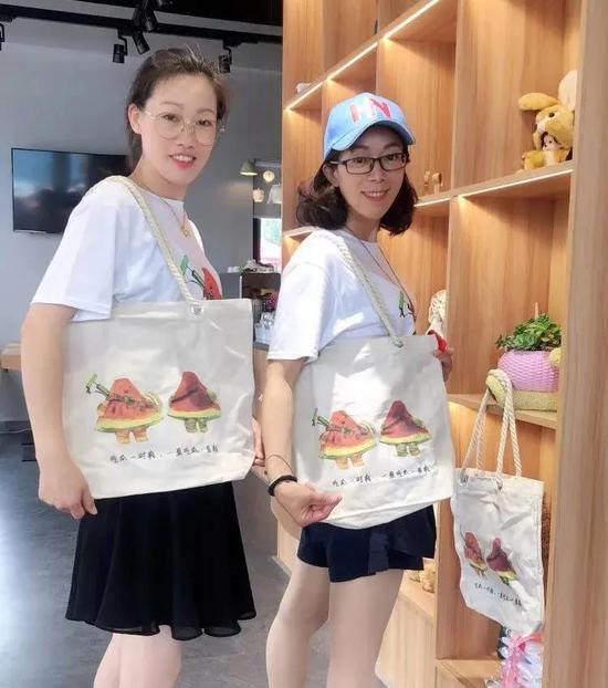 阮林芳(右)与小伙伴一起展示团队设计的文创产品