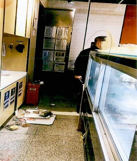 图说:男子苏某某将蛋糕和其他商品扫到地上。上海铁检院供图
