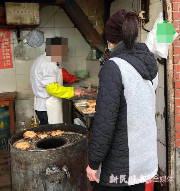 图说：食客正在等待油条出锅，但是店主并未戴手套和口罩 新民晚报记者 徐驰 摄