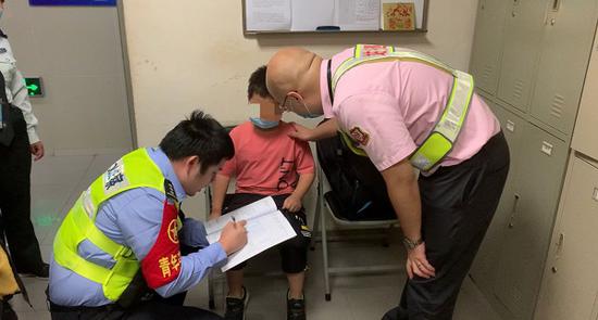 图说:地铁站工作人员和民警共同帮助走失的8岁男孩找到家人 车站供图