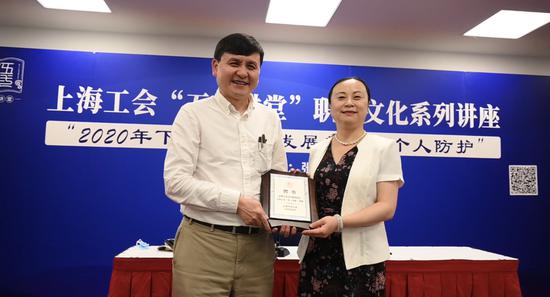 市总工会副主席桂晓燕向张文宏颁发“五一讲堂”讲师聘书。