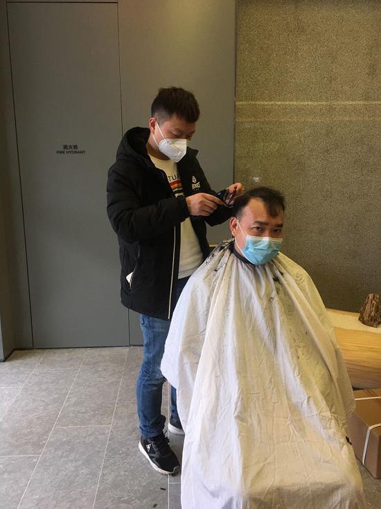 图说:志愿者给医护人员理发