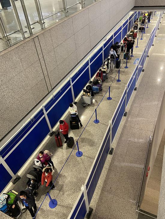 On November 23, 2020, in the international flight arrival area at Pudong Airport Terminal T2, incoming passengers must be isolated after undergoing temperature and nucleic acid tests.  The image shows passengers waiting in line to go to the isolation point.