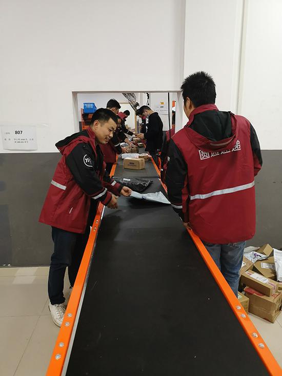 圆通快递长宁区镇宁路网点,快递员在把快件装车。