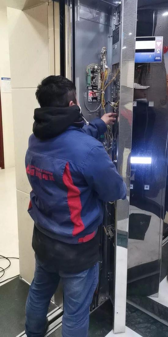 湖北宜昌的工作人员正在安装电梯声控设备。