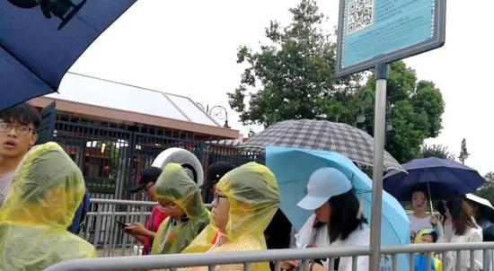 7月22日9点15分,台风“安比”正在接近,上海迪士尼乐园门口,游客正排队安检。 网友供图