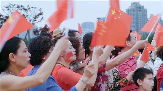 人们挥舞手中的旗帜,唱出心中的赞歌
